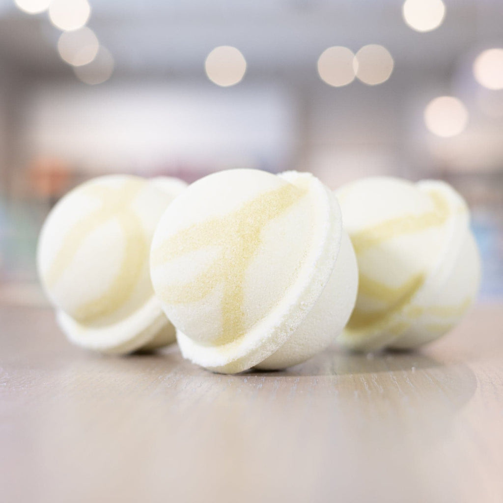 Three Good Morning Sunshine Bath Bombs with light yellow design lined up on counter 