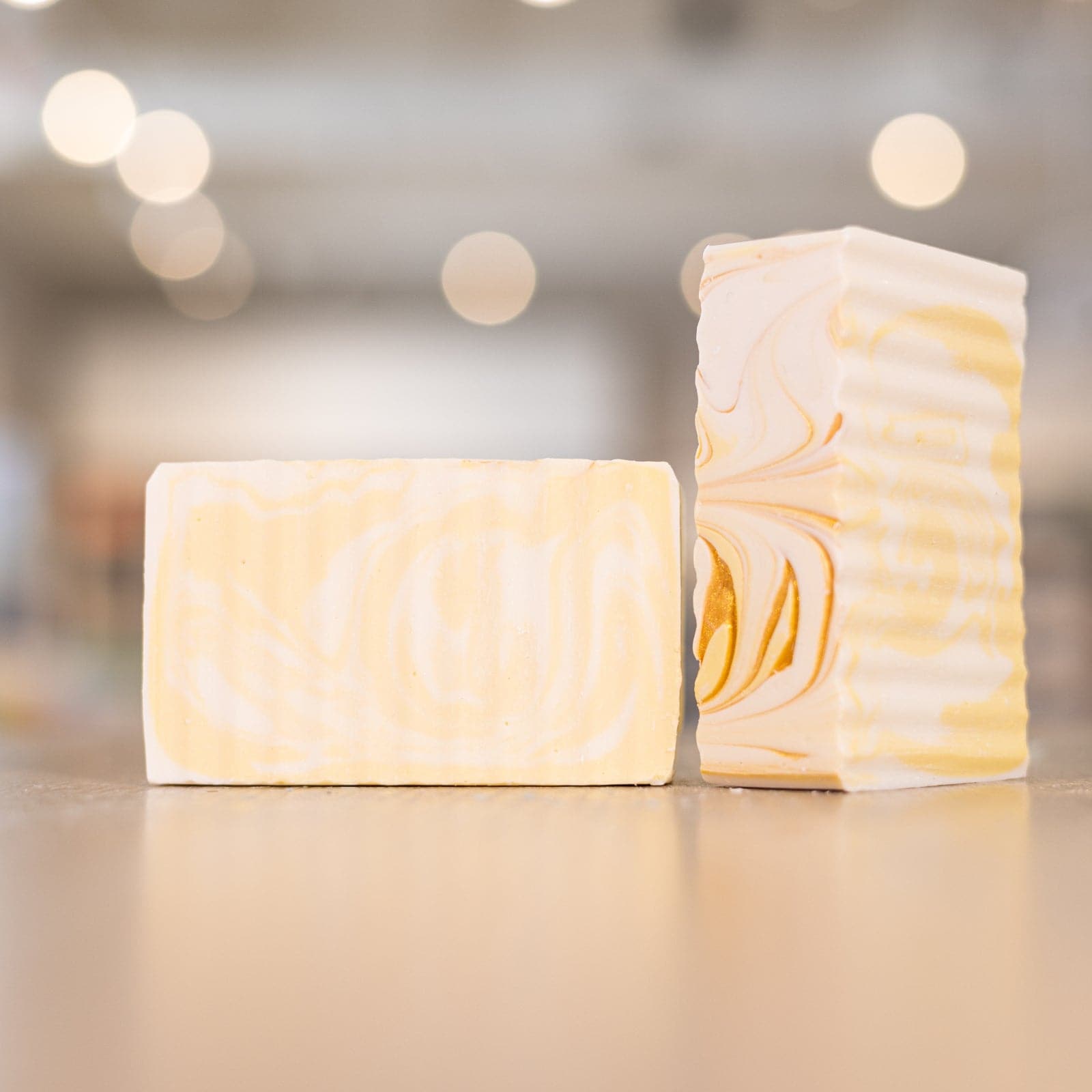 Two Good Morning Sunshine Soap Bars with bronze and yellow swirls on wooden counter