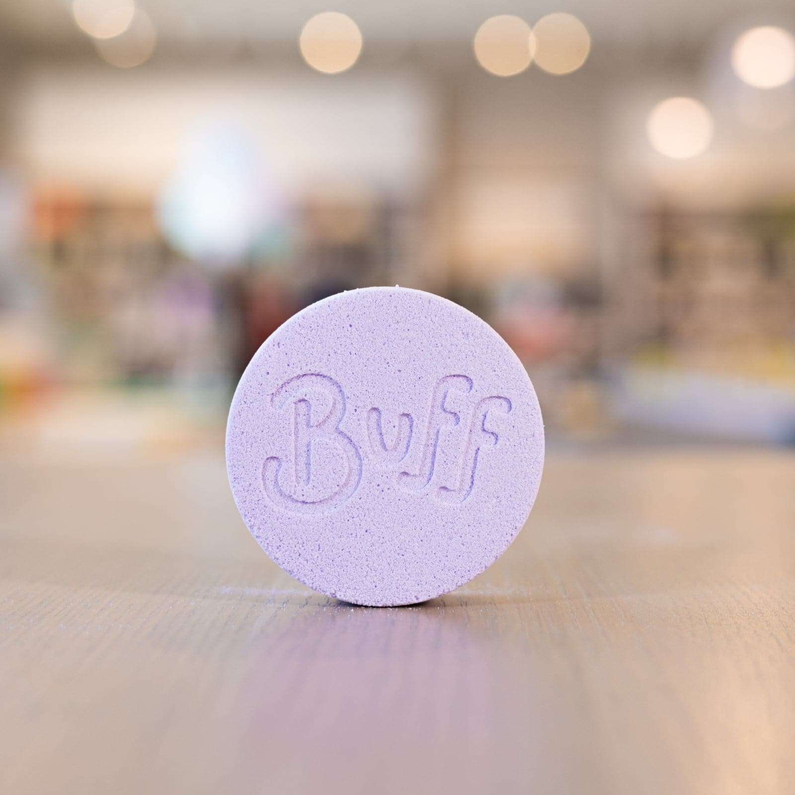 Buff City Soap's lavender colored and scented shower fizzy soap with buff written on its side