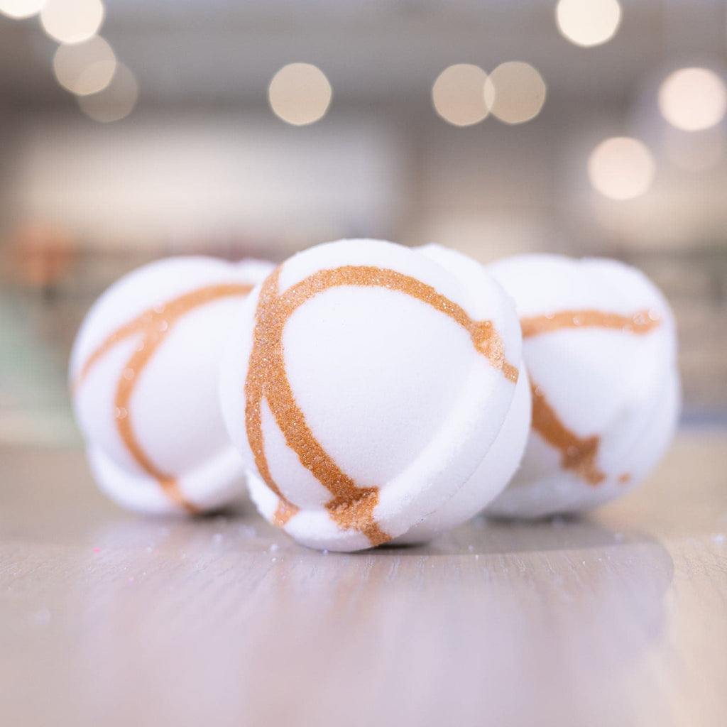 Three Narcissist Bath Bombs with bronze design on wooden counter