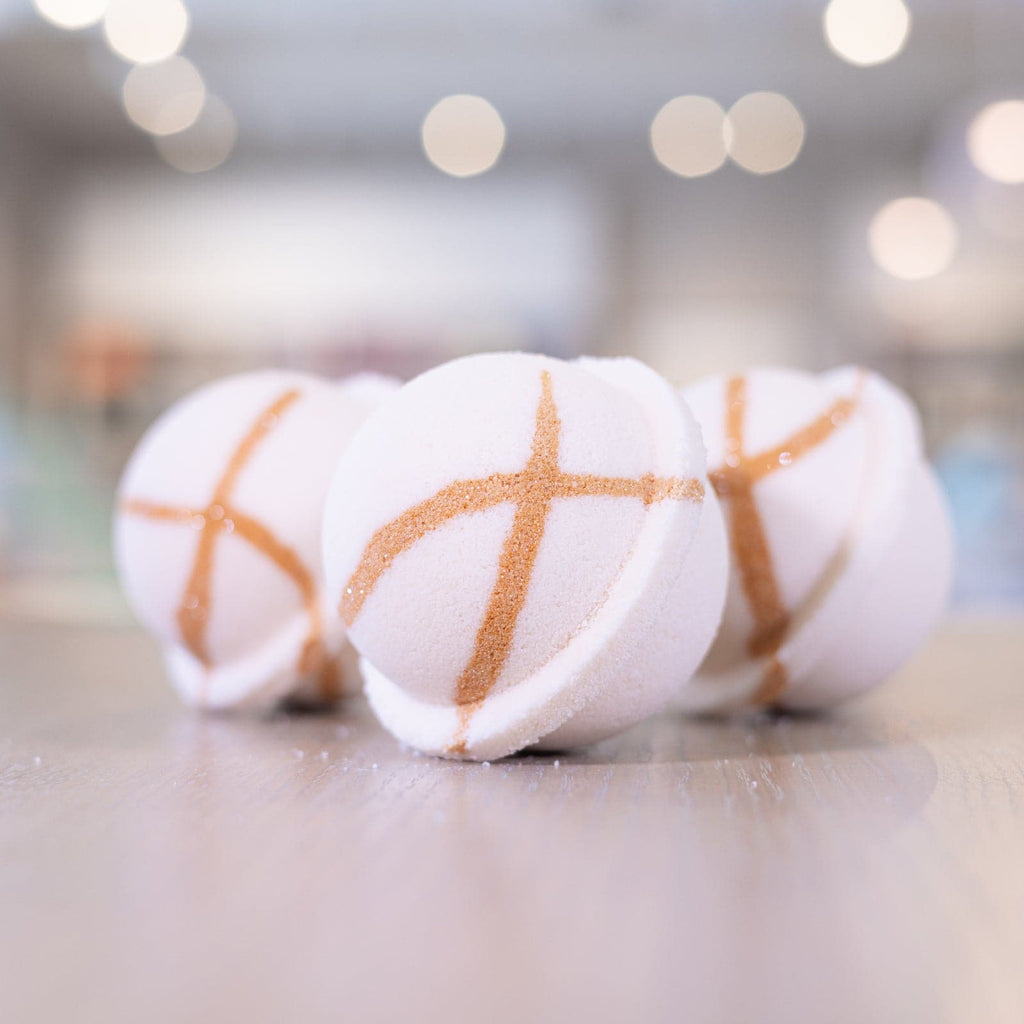 Three white bath bombs lined up on counter with gold bronze design 